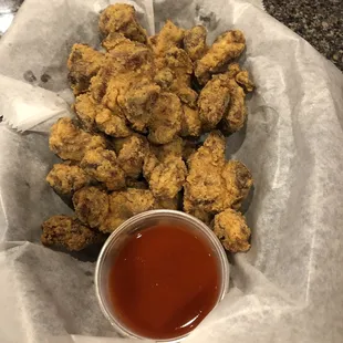 a basket of fried chicken with a side of ketchup