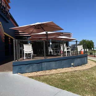 a patio with chairs and umbrellas