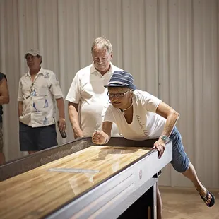 a man playing shuffleboard