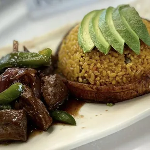 Pepper  Filet Mignon , with our Spanish Yellow rice ,sweet plaintain and avocado