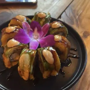 The Escobar Roll: Spanish rice, shrimp tempura, churrasco, and cream cheese. Topped with avocado, plantains, and chimichurri.