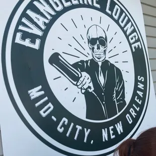 a woman leaning against a sign