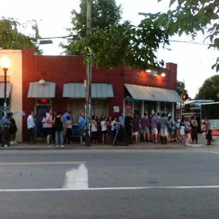 a line of people waiting to cross the street