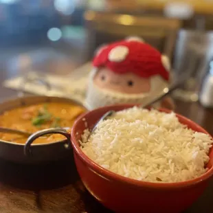 a bowl of rice and a pot of curry