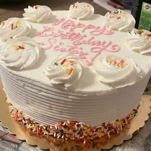 a birthday cake with white frosting and sprinkles