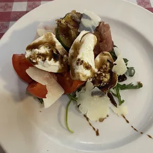 Caprese Salad with cornmeal crusted zucchini, balsamic reduction and shaved Parmesan.