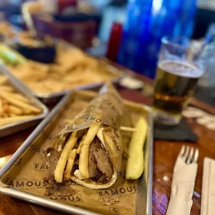 Gyro with fries and pickle.
