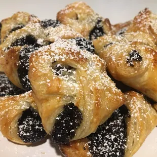 a plate of pastries covered in powdered sugar