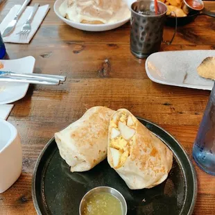 Breakfast burrito (cinnamon roll in background)