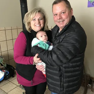 a man and woman holding a baby