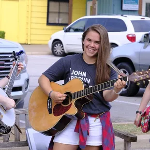 three young girls playing guitar
