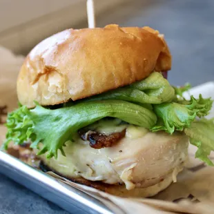 a chicken sandwich with lettuce and cheese