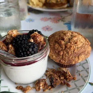 a muffin and a bowl of blueberries