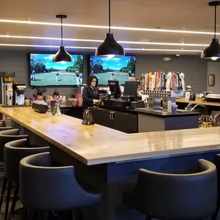 a bar with chairs and a television