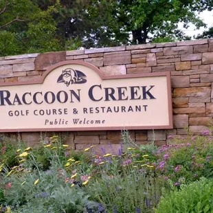 a sign for raccoon creek golf course and restaurant