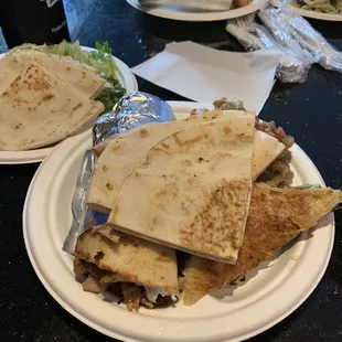 A chicken gyro dinner with a Greek salad, spanakopita and eggplant.