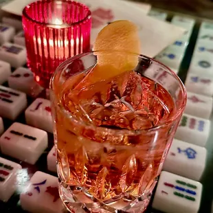 Cocchigroni. Botanist Gin, Cocchi Americano, Velvet Falernum, Campari, orange twist. On a rock.