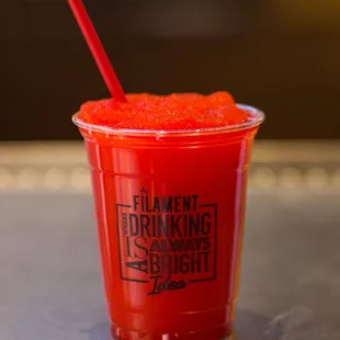 a red drink in a plastic cup
