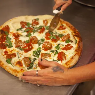 a person cutting a pizza