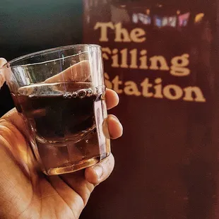 a hand holding a glass of whiskey