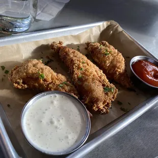 a tray of fried chicken with dipping sauce