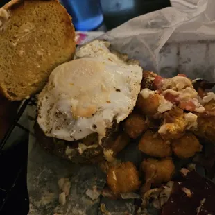 Carnivor burger with an egg &amp; jalapenos with Tater tots