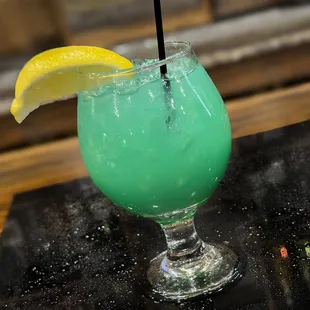 a green drink with a slice of lemon