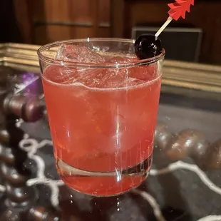 a cocktail with a cherry garnish