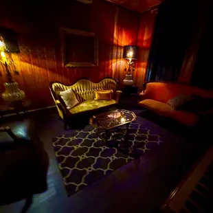 a living room with couches and a piano