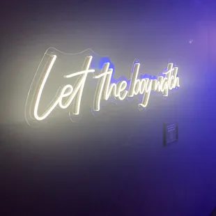 a neon sign that says let the boy with it
