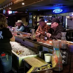 a bar with people sitting at the bar