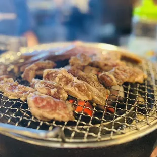 a bunch of meat cooking on a grill