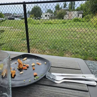 Patio backs onto grassy lot.