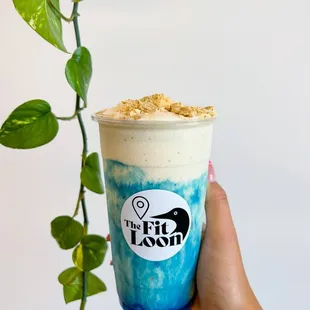 a hand holding a cup of ice cream