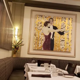 a dining room with a painting on the wall