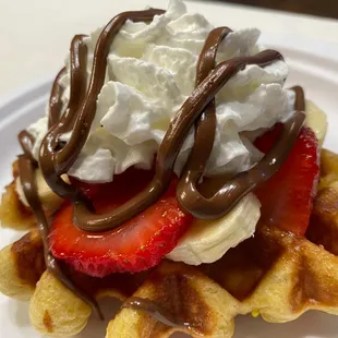 Authentic Belgium Waffle topped with strawberries, bananas, whipped cream and Nutella. Our most popular dessert!