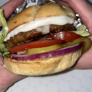 a hand holding a hamburger