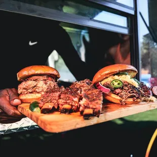 two sandwiches on a wooden cutting board