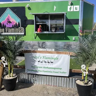 a green food truck parked in a parking lot