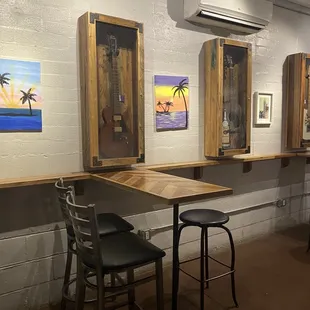 a bar with stools and paintings on the wall