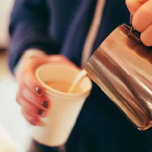 a person pouring a cup of coffee