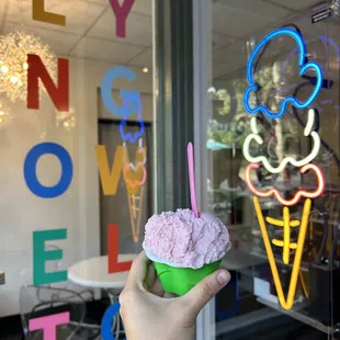 a hand holding a cup of ice cream
