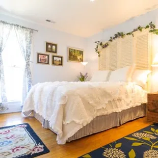 The Provence Room features a queen bed and custom headboard and decorated in French Country. Ensuite full bathroom