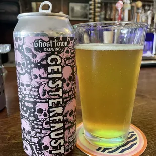 a glass of beer next to a can