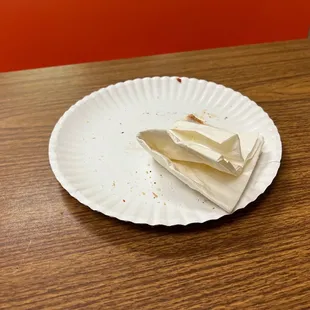 a piece of cheese on a paper plate