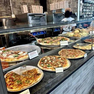 a variety of pizzas on display