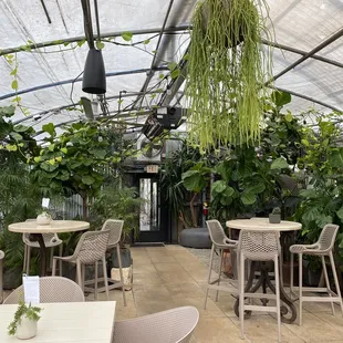 a greenhouse with tables and chairs