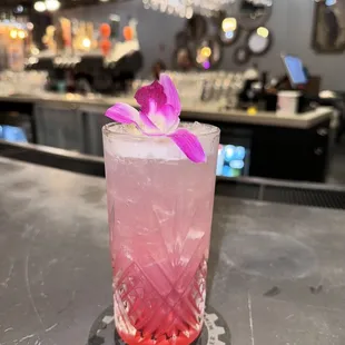 a pink drink with a purple flower
