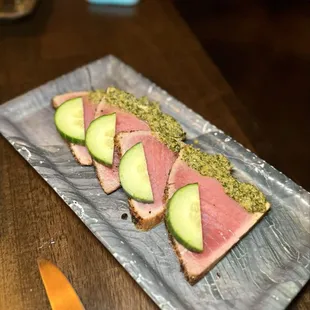 Seared ahi tuna - coated in bold spices, rare, topped with cucumber, lime, cilantro, garlic, ginger