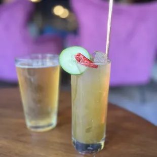 two glasses of beer and a cucumber